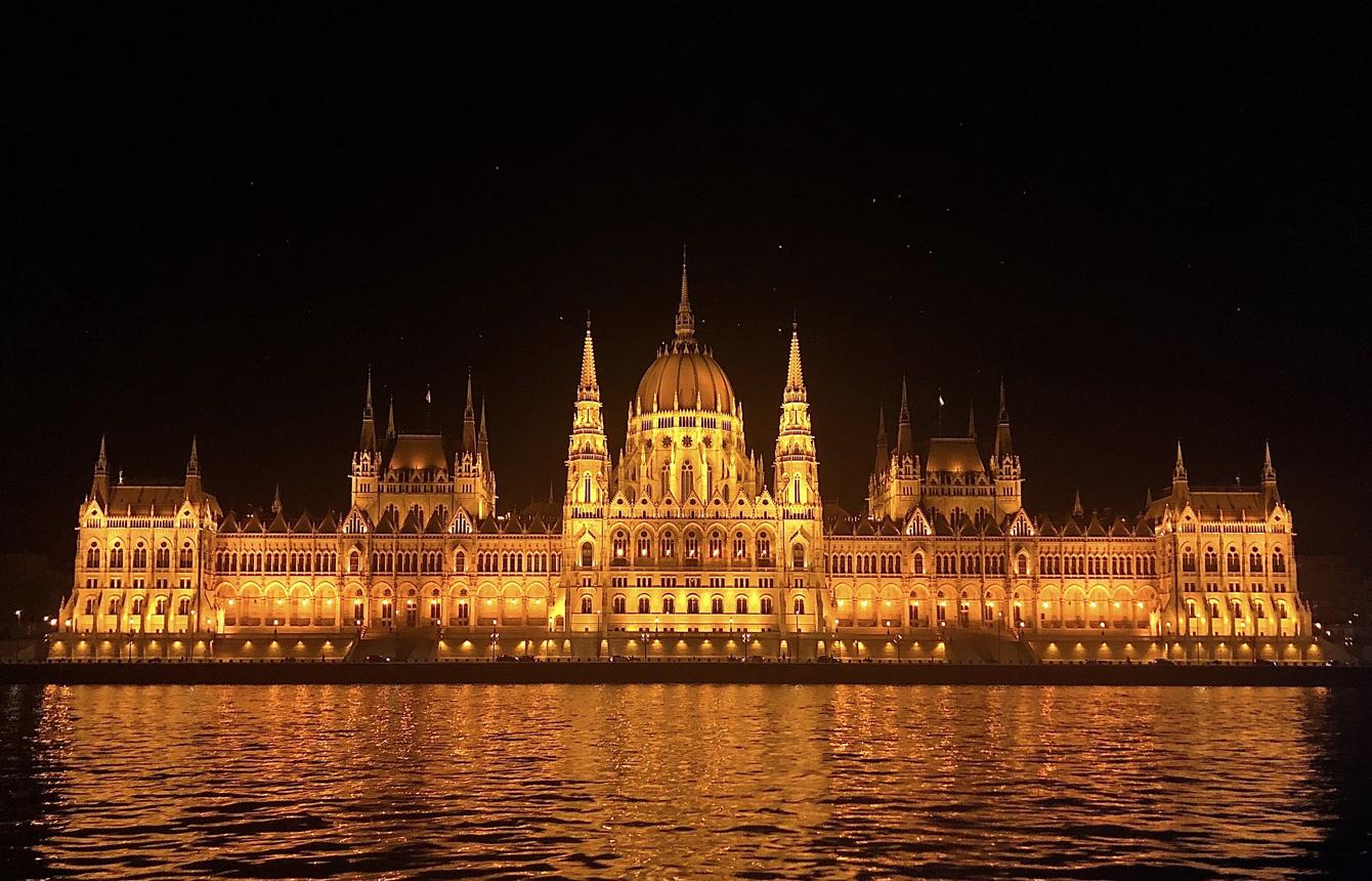 The Hungarian Parliament Building lit up at night, reflected in the Danube.